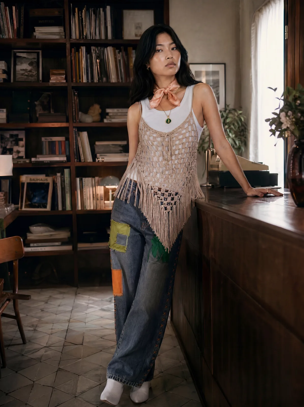 Editorial frame — modelka w domowej bibliotece, drewniane regały, naturalne światło z okna